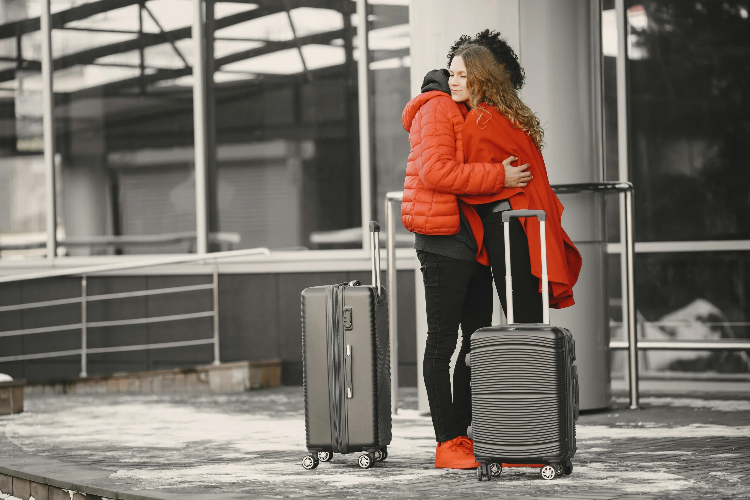 A man and a woman hugging each other at a train station.
