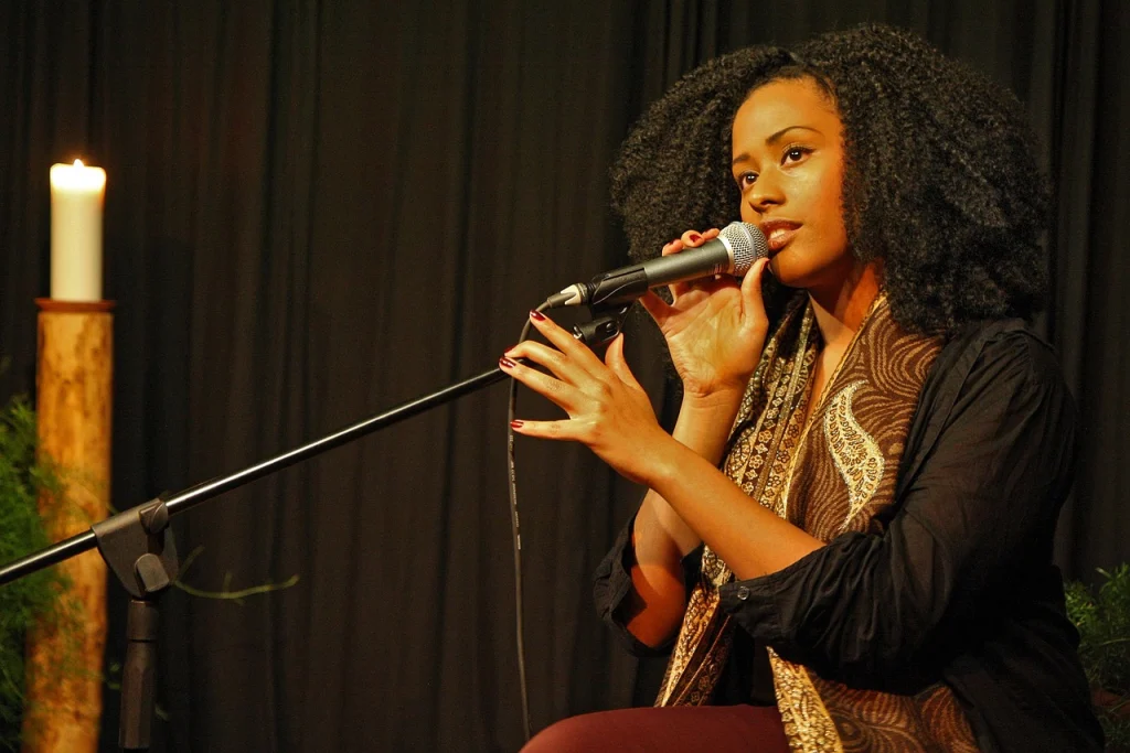 A woman holds a microphone while she sings.