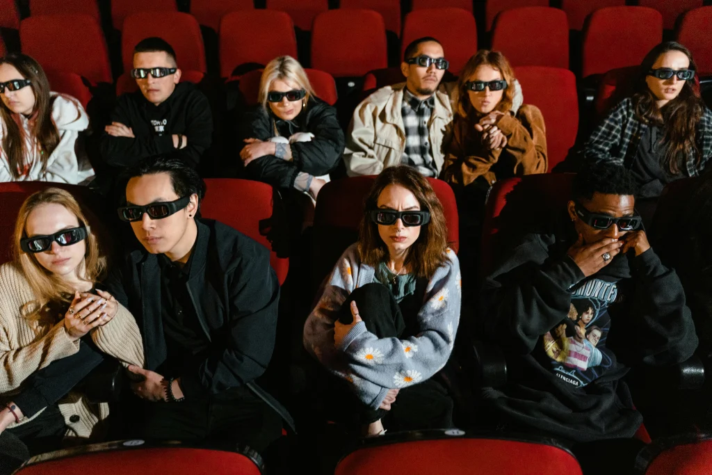 This image shows a group of people wearing 3D glasses while watching a movie at a movie theater.